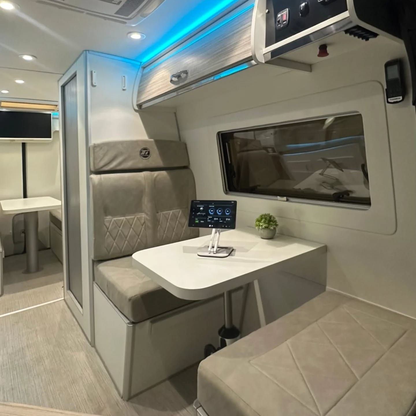 Forward dinette seen from the corridor, with the management tablet on the table