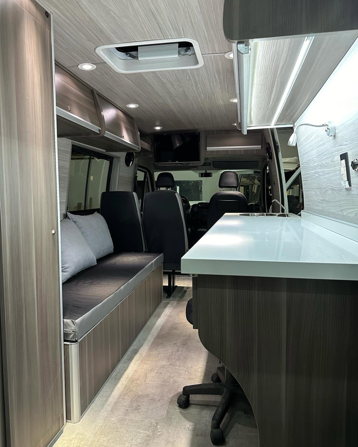 Vista general del interior revestido en laminado símil roble gris, con la mesada blanca a la derecha