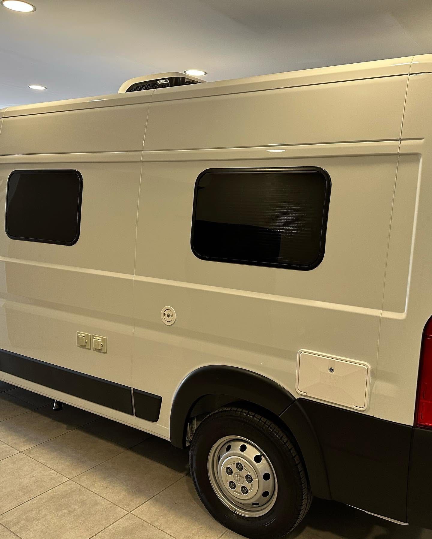 Lateral de la Citroën Jumper con las dos ventanas de motorhome enrasadas y el aire acondicionado de techo