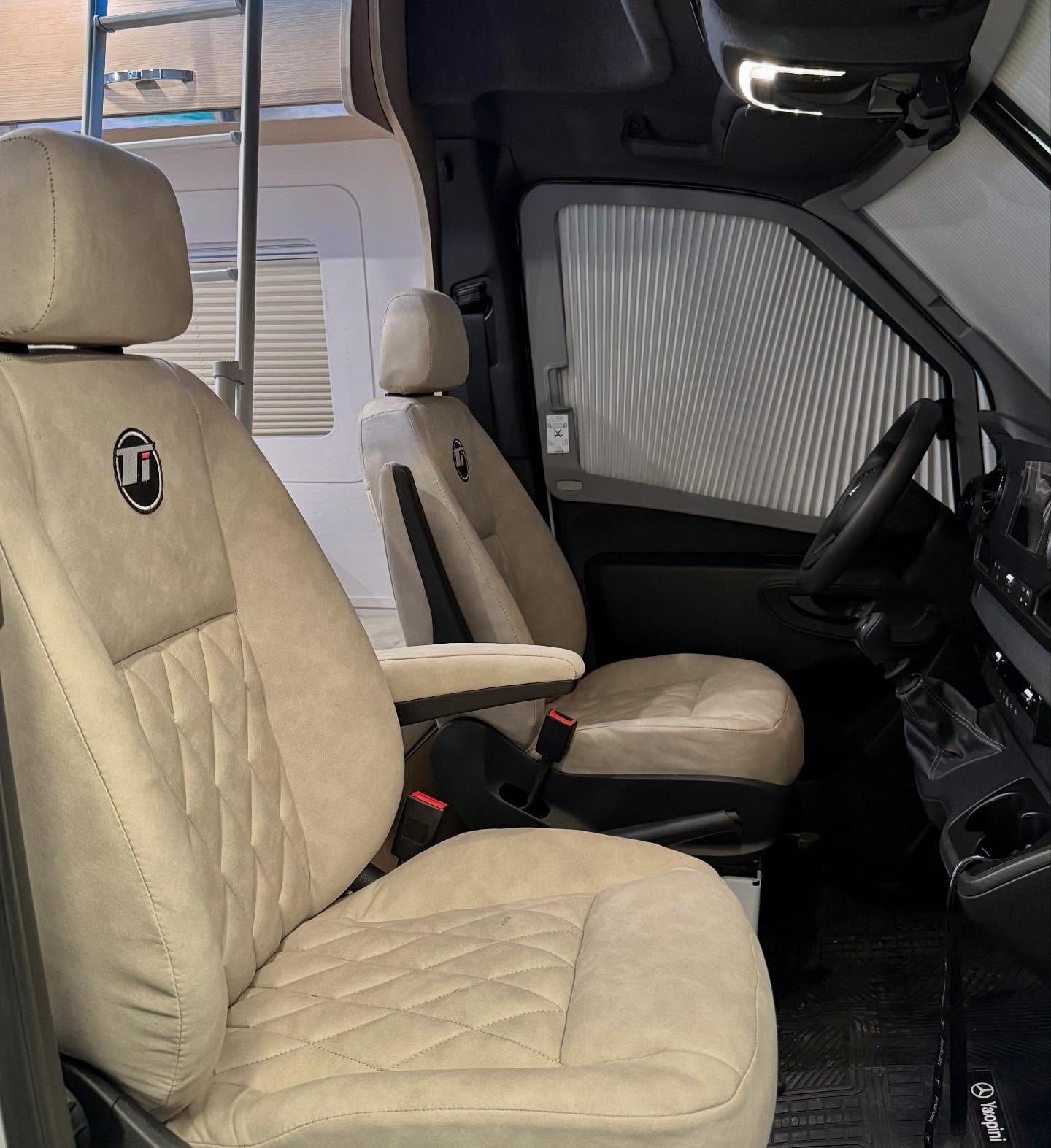 Cabina de la Sprinter con butacas tapizadas a medida y el emblema Ti bordado
