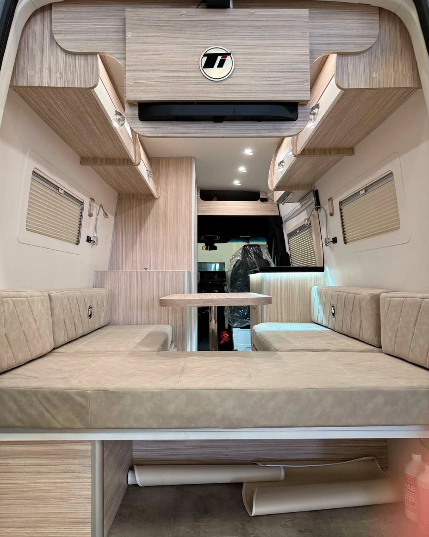 Dinette made up as a double bed, with the Ti emblem on the rear unit