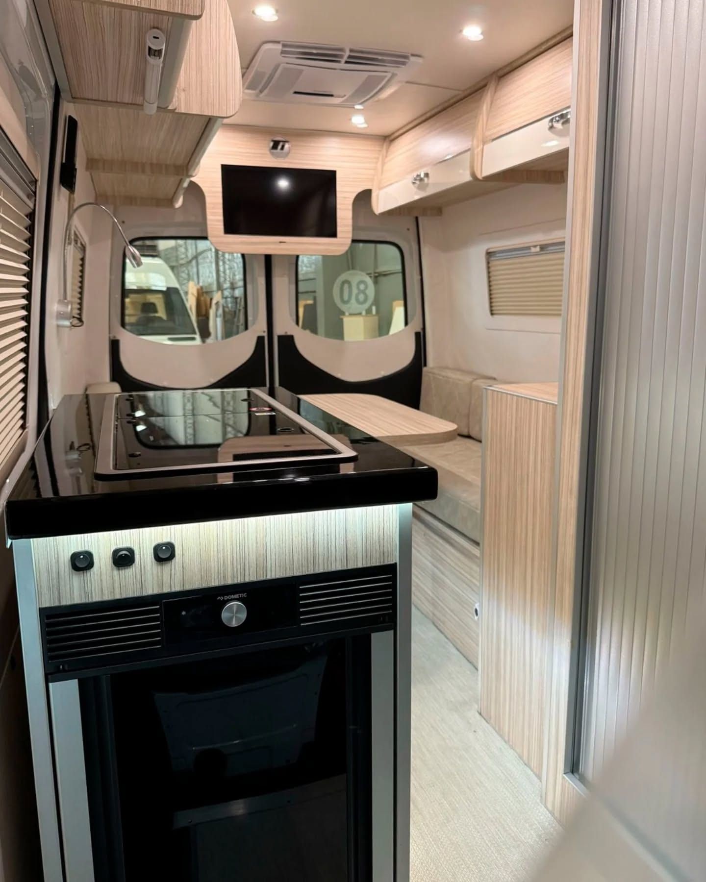 Dometic under-counter fridge and ceramic hob, with the dinette beyond