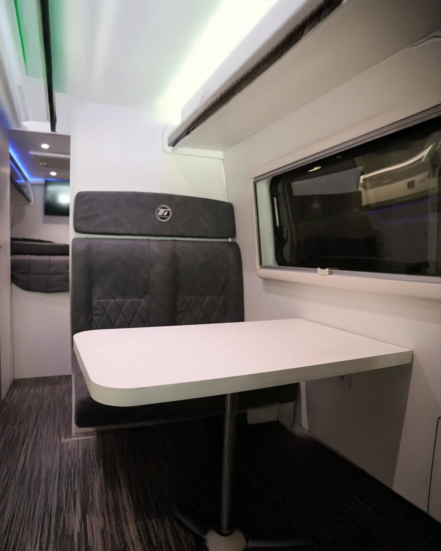 Comedor de la Sprinter 517 XL visto desde el pasillo, con la cama al fondo