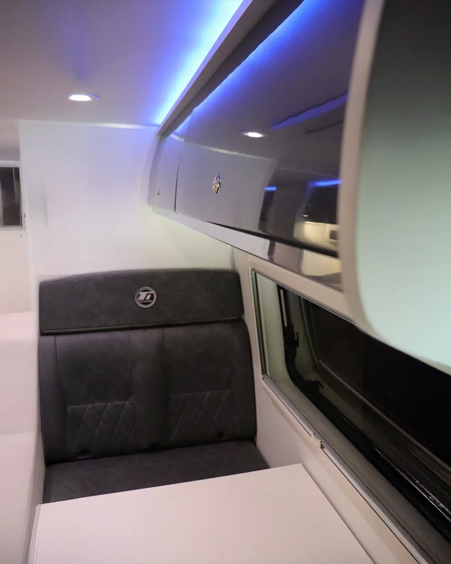 Comedor lateral de la Sprinter 517 XL con butaca gris y mesa blanca junto a la ventana