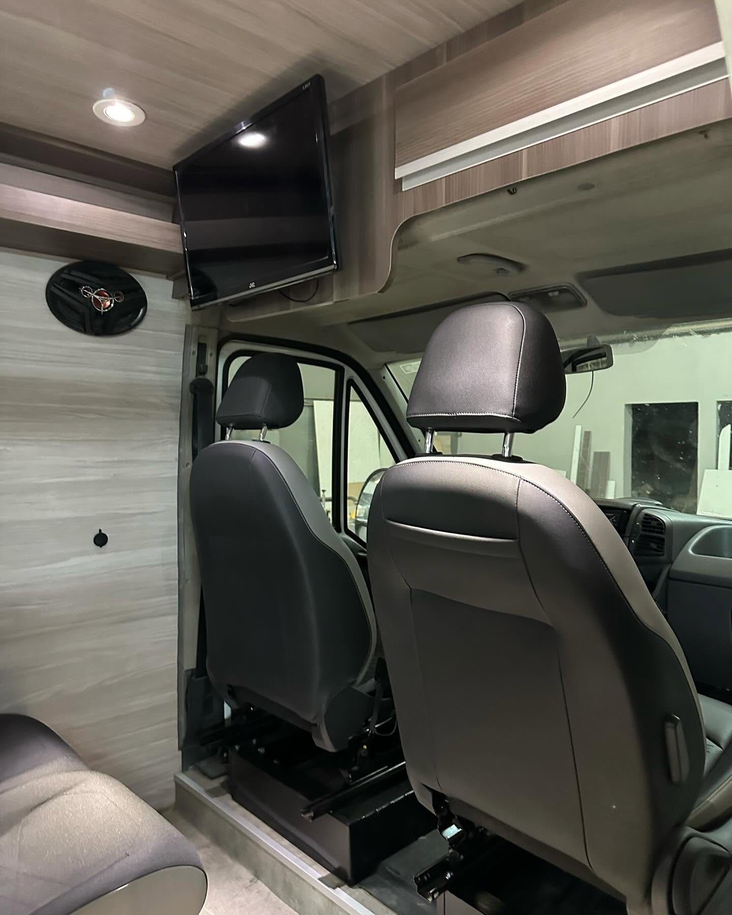 Butacas de cabina y TV montado sobre el mueble alto de la Fiat Ducato
