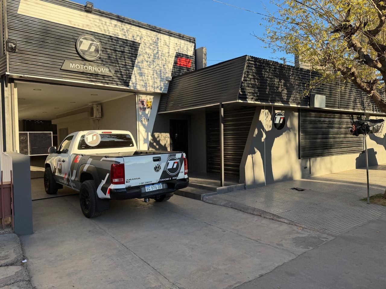 Frente del taller en Avellaneda 2261, con el portón abierto y la camioneta de Ti Motorhome en la entrada